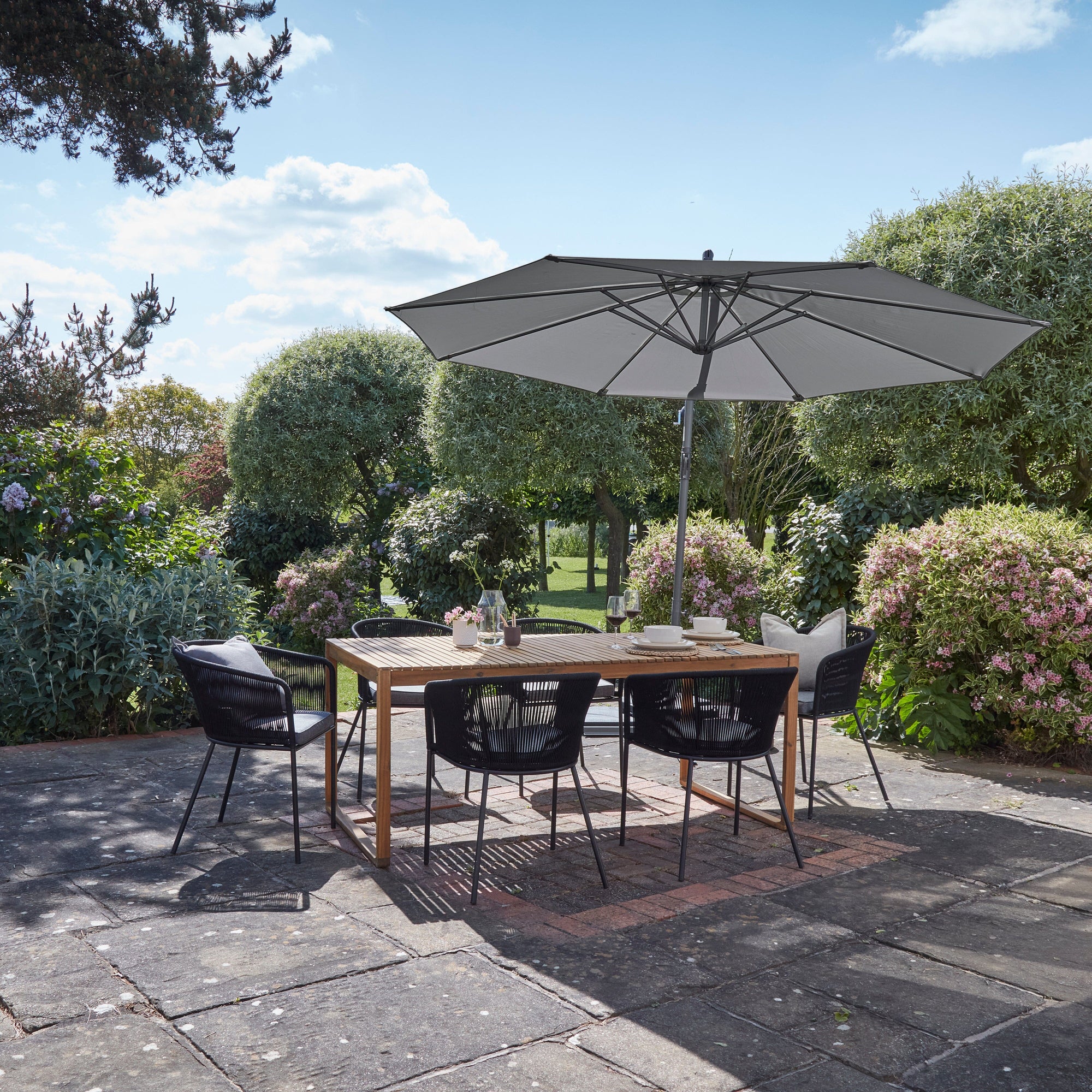 Lennox Table With 6 Hali Black Dining Chairs and Grey Lean Over Parasol