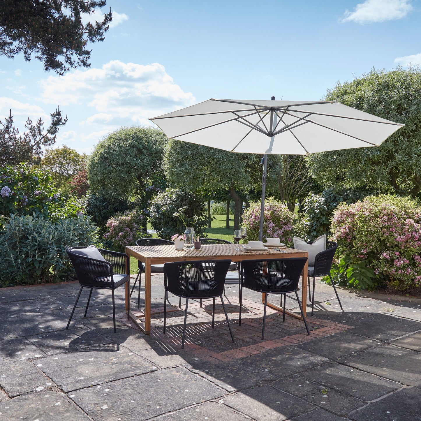 Lennox Table With 6 Hali Black Dining Chairs and Cream Lean Over Parasol